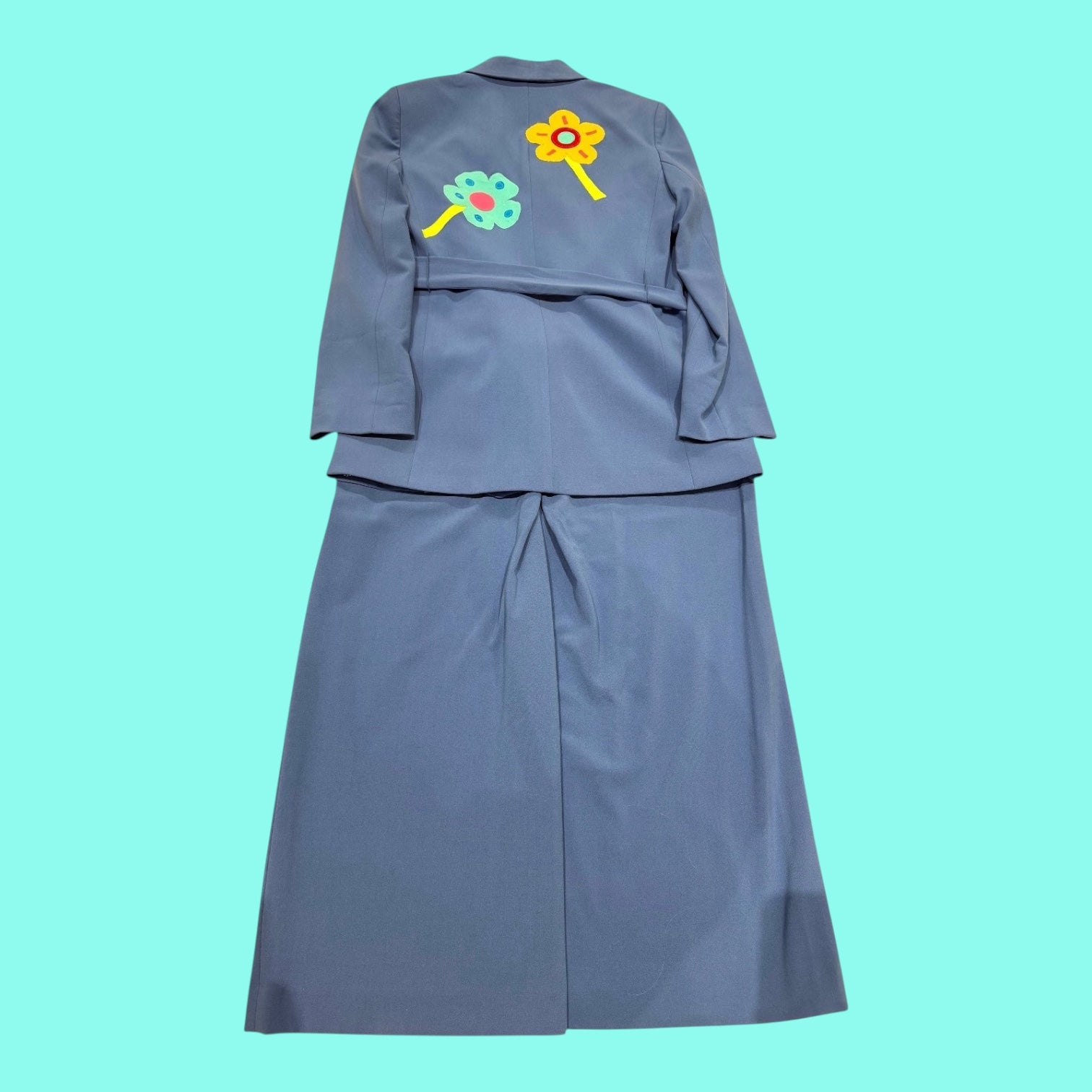 Blue Greenie blue wide-leg pant suit featuring a jacket with yellow and teal floral appliqué on the back