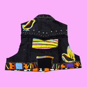 Blue Greenie Eivy T2T black denim vest with hand-stitched colorful appliqué, painted patterns, and metal studs.