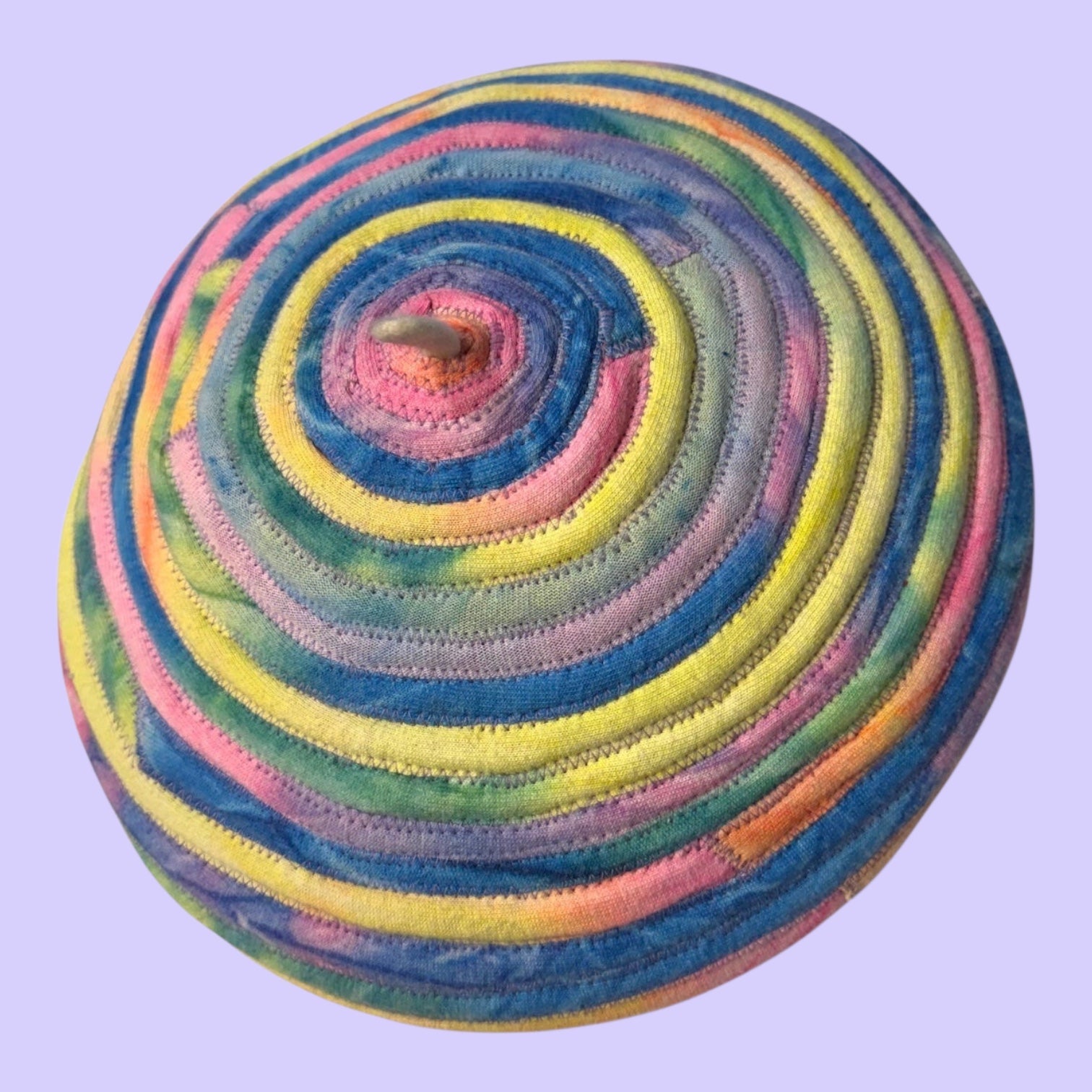 Blue Greenie eggshell white beret featuring concentric pastel tie-dye t-shirt fabric strips in a spiral design.