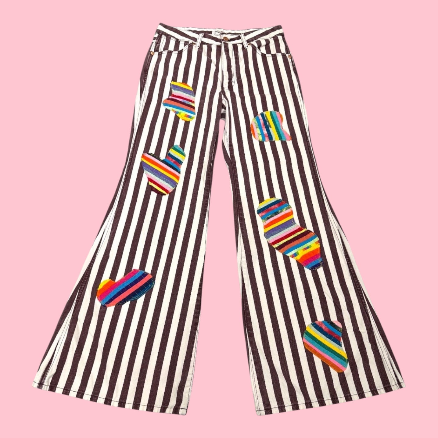 Blue Greenie wide-leg jeans with brown and white vertical stripes and colorful striped heart-shaped patches.